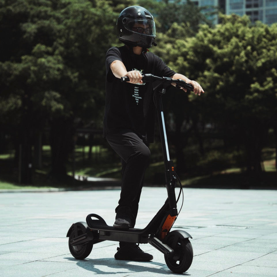 Person riding an electric scooter in a park-like setting