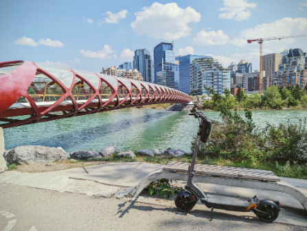Apollo electric scooter in shade by a river path during a summer city ride in Calgary
