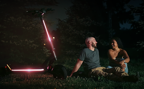 Couple sitting in the dark with Apollo Scooter as light