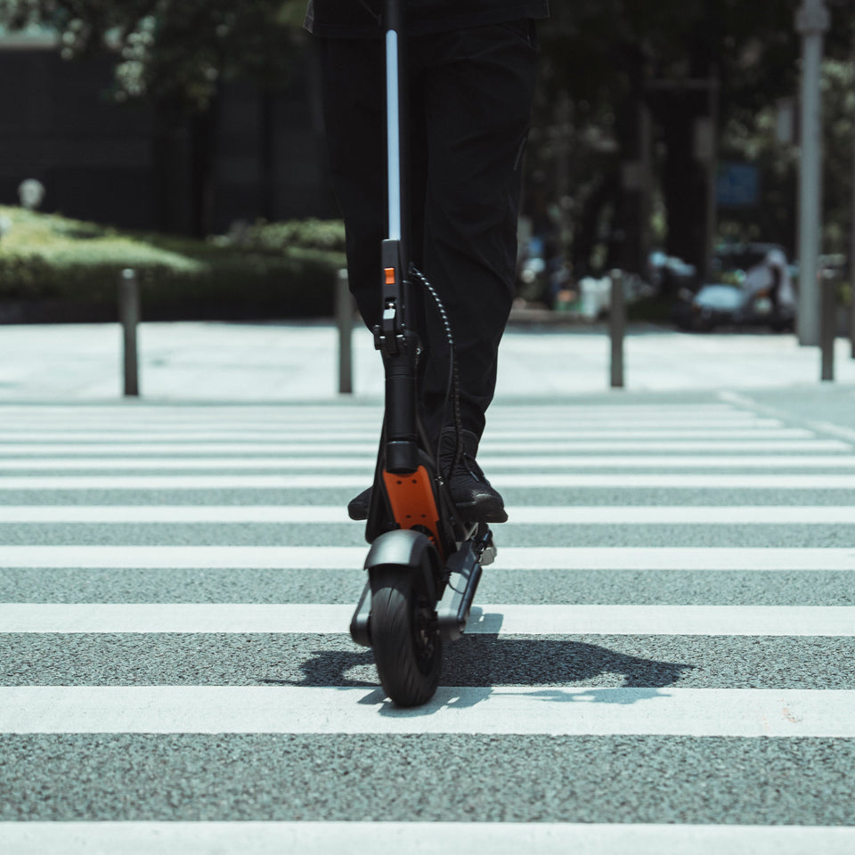 Person riding an electric scooter on a crosswalk